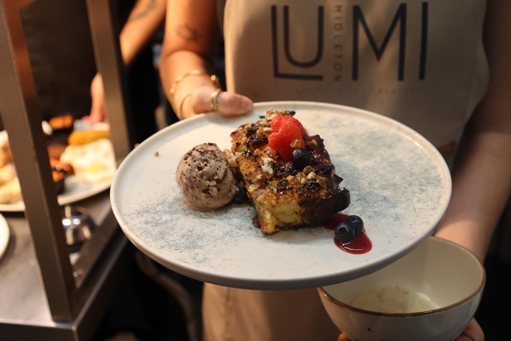 French toast with berries, praline and chocolate ice cream, presented by a LUMI team member